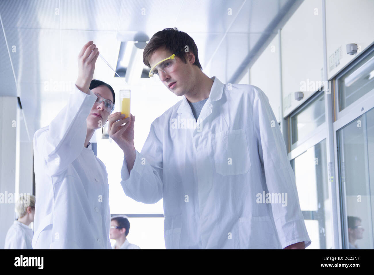 Studenti di chimica miscelazione di prodotti chimici in laboratorio Foto Stock