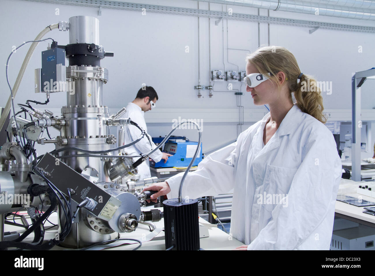Due scienziati indossando camici da laboratorio utilizzando apparecchiature scientifiche Foto Stock