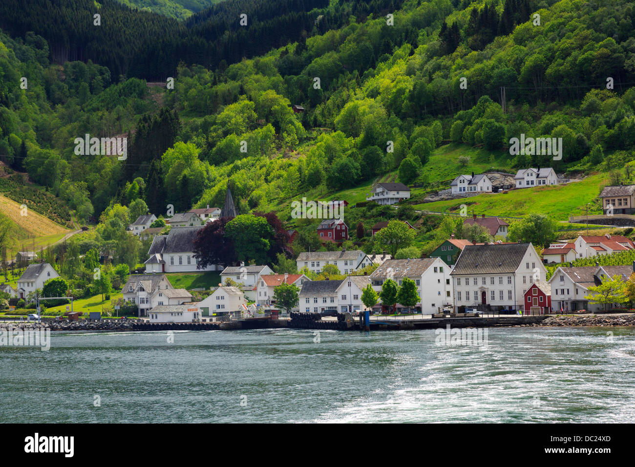 Vista offshore attraverso Hardangerfjorden per porto e villaggio costiero di Utne, Ullensvang, Hardanger, Hordaland, Norvegia Foto Stock
