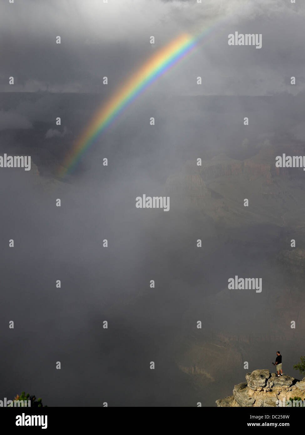 Rainbow sul Grand Canyon con persona godendo della vista Foto Stock