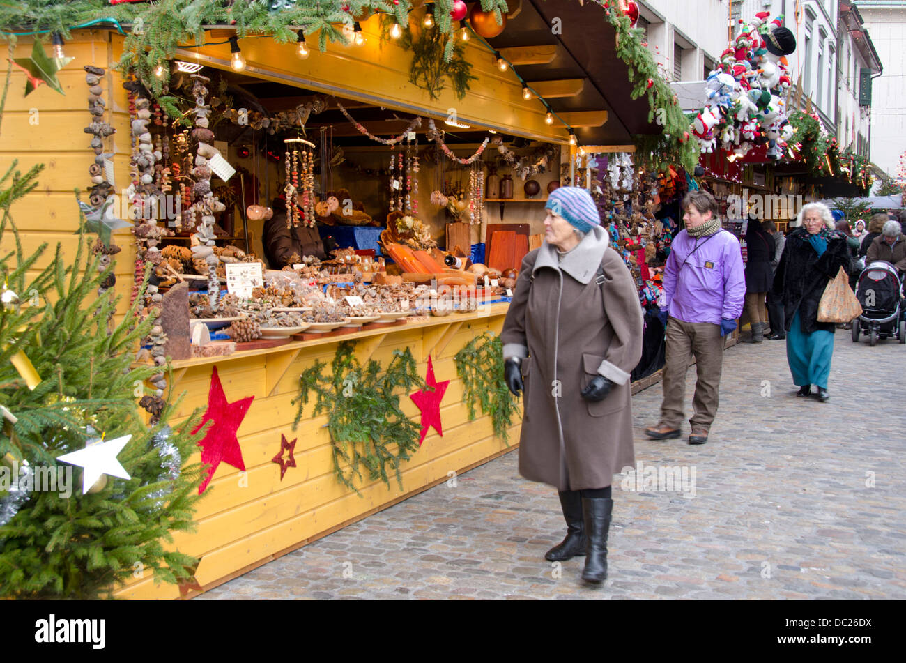 La Svizzera, Basilea. Basilea vacanza invernale Mercato a Barfusserplatz. Fornitore tipico stand al mercato invernale con la gente a fare shopping. Foto Stock