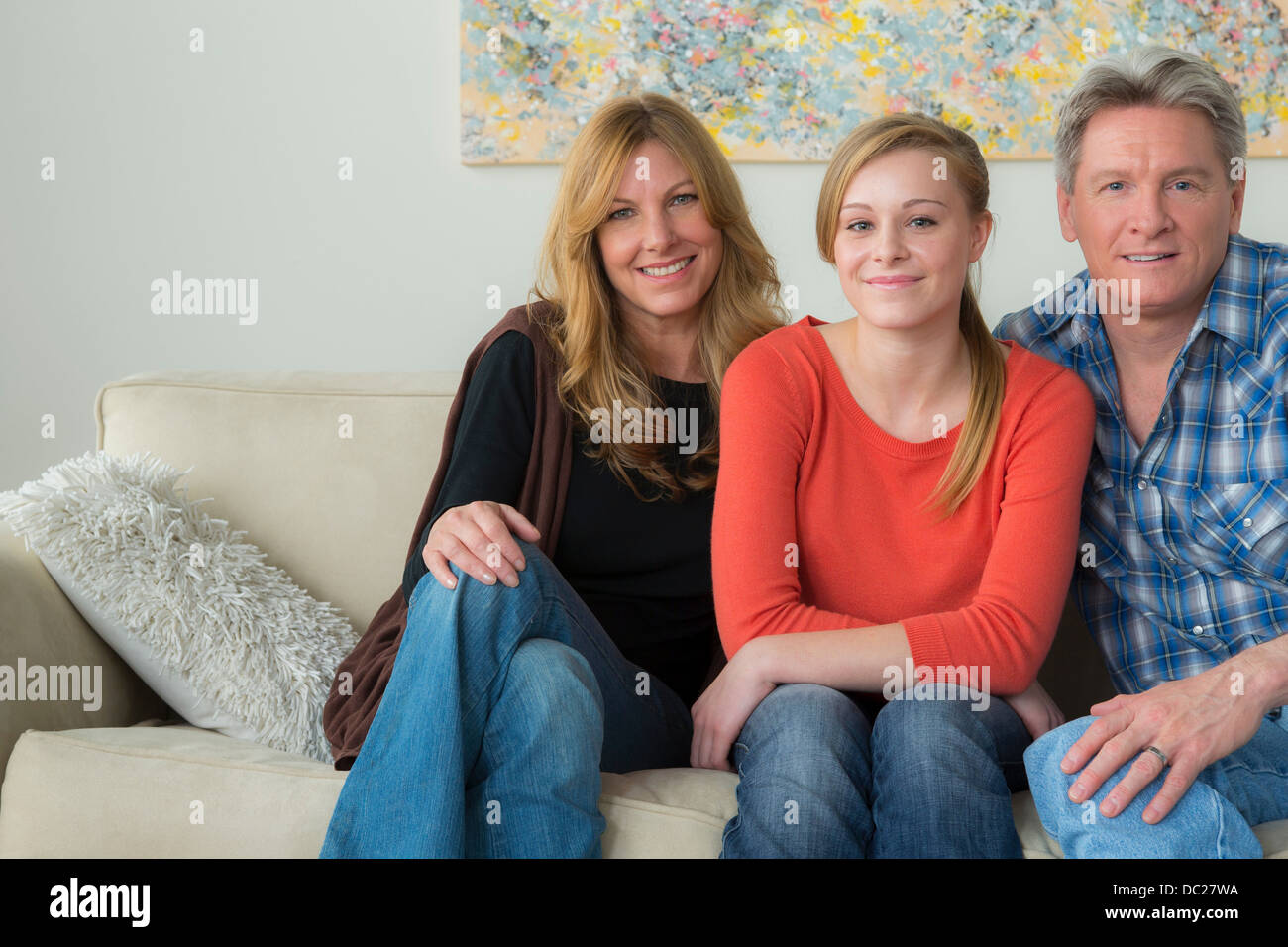 Ritratto di padre e madre con figlia adolescente sul divano Foto Stock