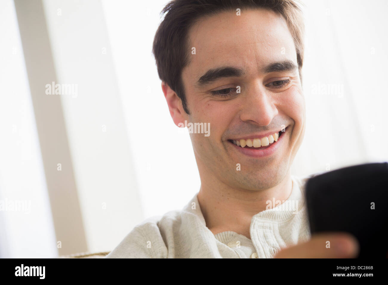Metà uomo adulto con un telefono cellulare, sorridente Foto Stock