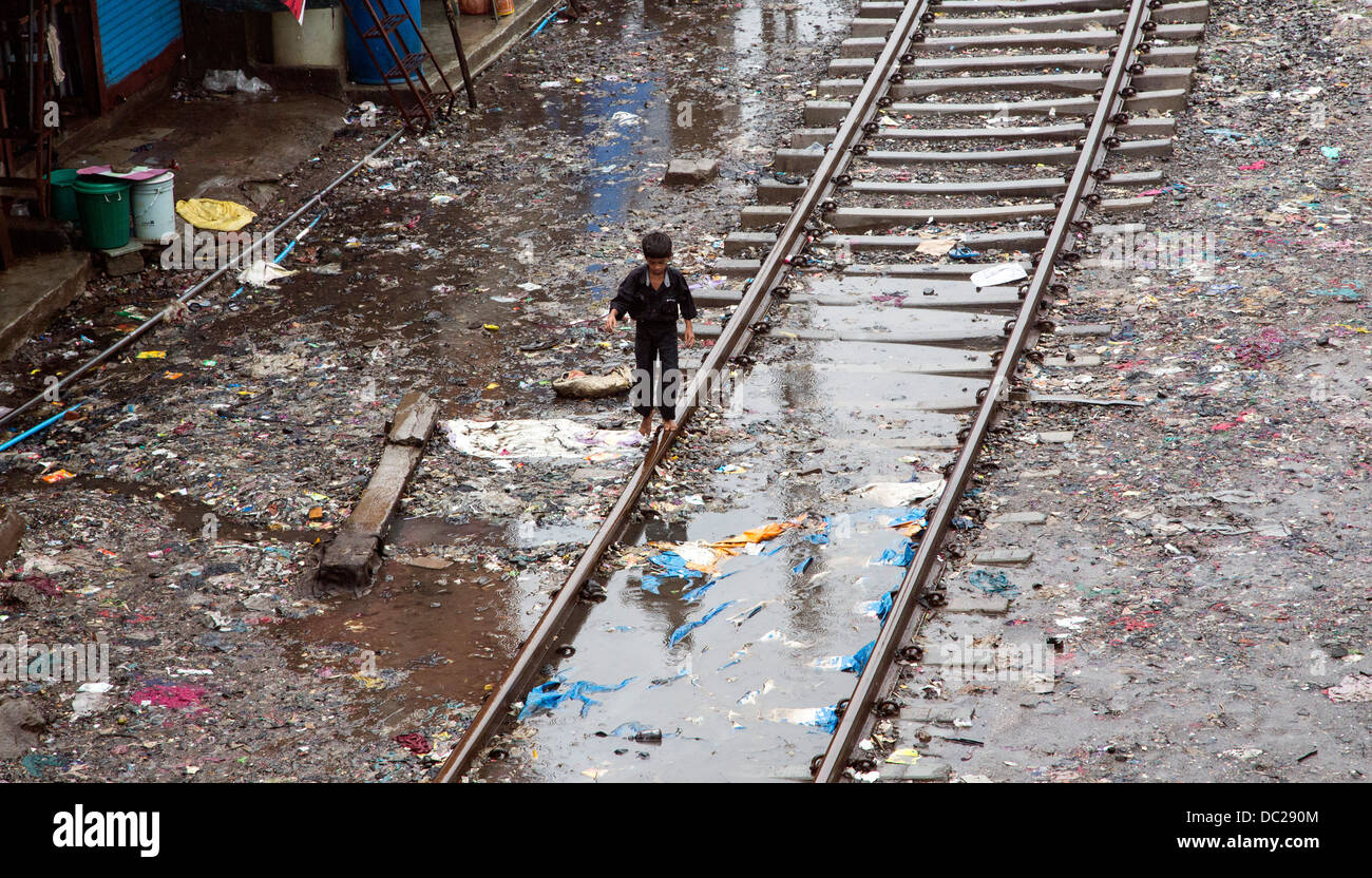 Kid sul treno via rotaie nella baraccopoli zona sporca Foto Stock