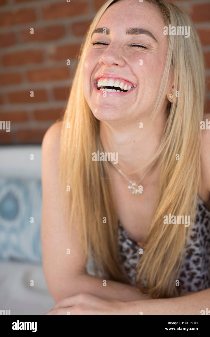 Ritratto di giovane donna con capelli lunghi biondi ridere Foto Stock