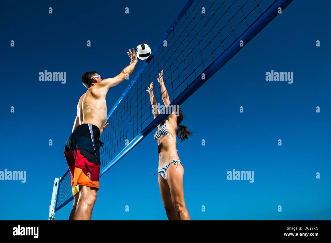 Due i giocatori di beach volley bloccando al netto Foto Stock