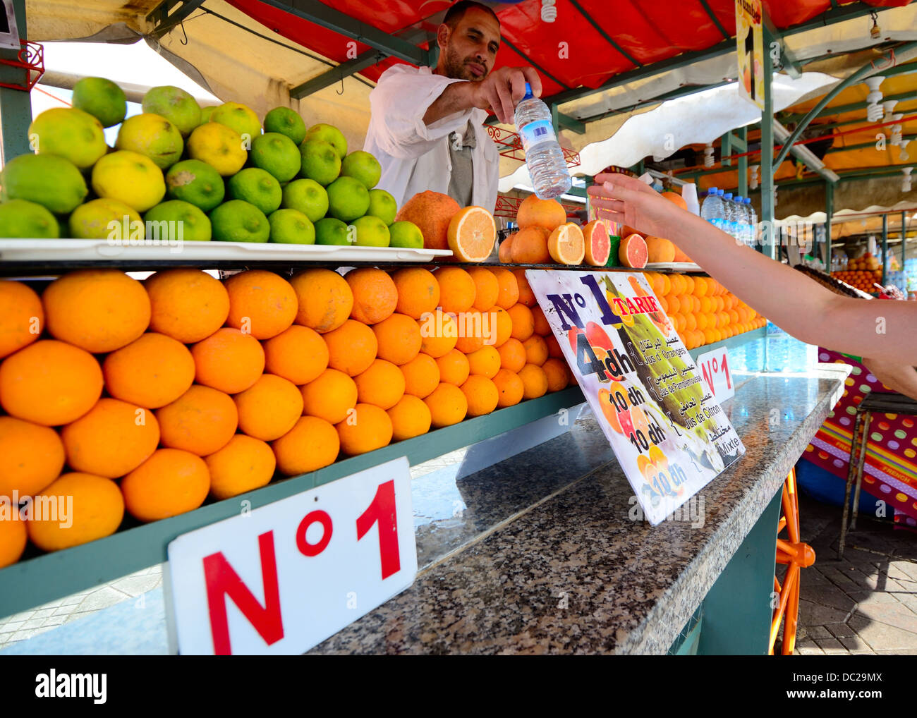 Piazza Jamaa El Fna di Jemaa El Fnaa Djema El-Fna Djemaa Orange venditore bancarella vendendo una bottiglia d'acqua numero uno 1 merchant marrakech marocco Foto Stock