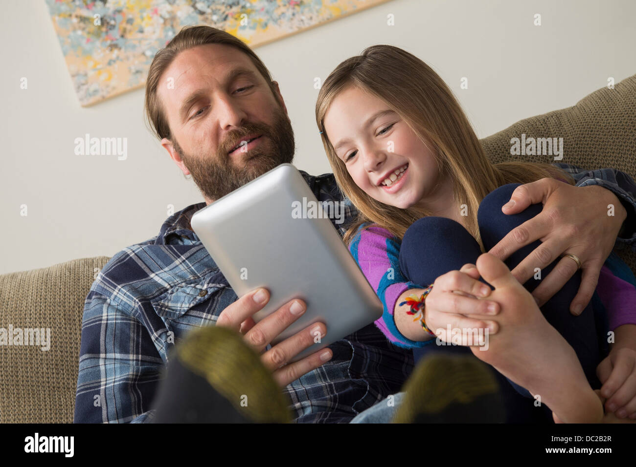Padre e figlia guardando a tavoletta digitale Foto Stock