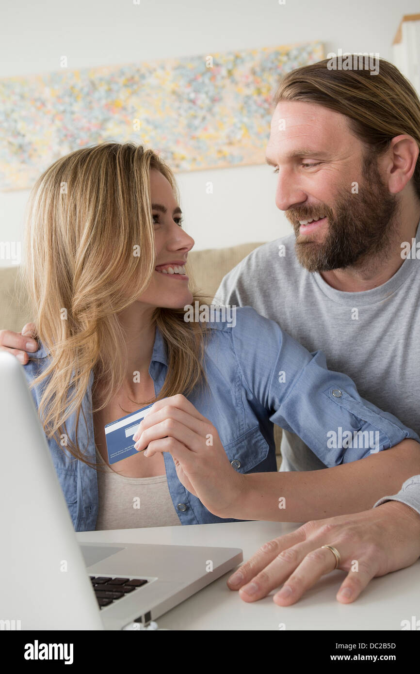 Donna con carta di credito guardando il marito Foto Stock
