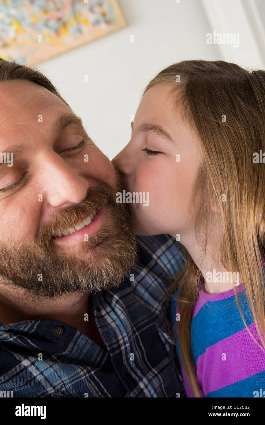 Figlia di baciare padre sua guancia Foto Stock