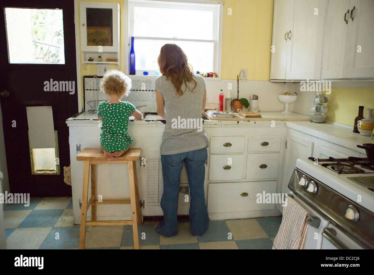 La madre e il bambino al lavello da cucina Foto Stock