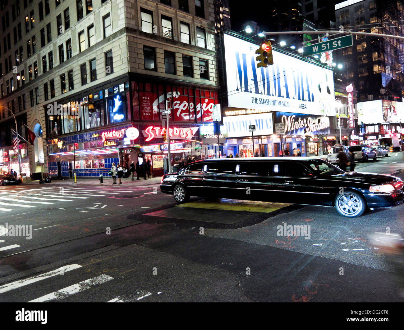 Vista notte le luci di Broadway con pedoni e lunga elegante stretch limousine attraversando Broadway intersezione Manhattan Foto Stock