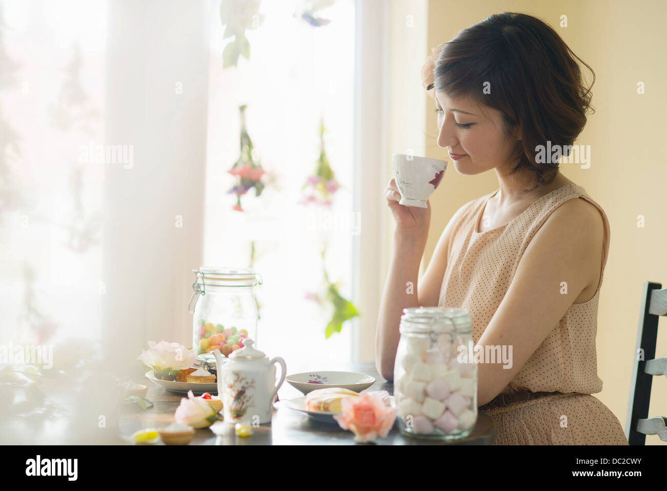 Donna che guarda in basso a tazza da tè Foto Stock