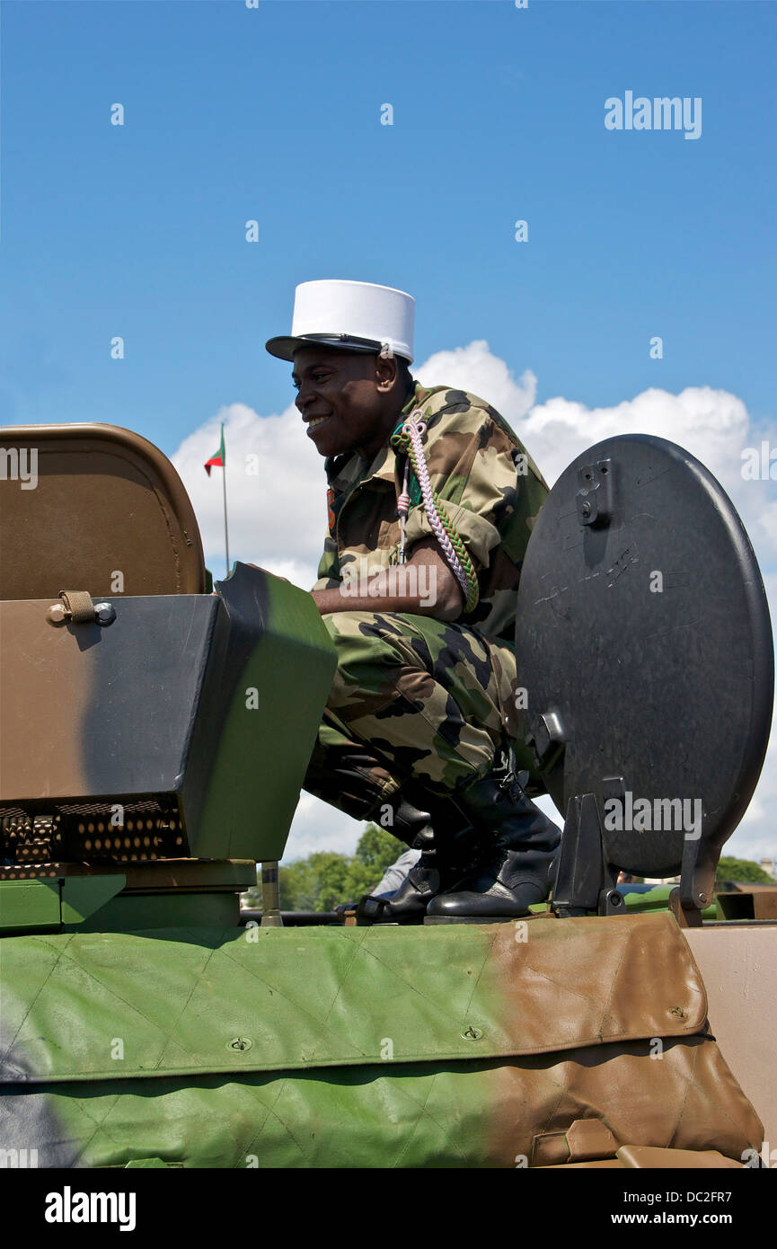 Un soldato della Legione straniera francese si vede accovacciato accanto al suo carro armato, mostrando la presenza militare e la disciplina della Legione in azione. La Legione straniera francese è nota per le sue unità da combattimento d'élite e per il rigoroso addestramento. Foto Stock