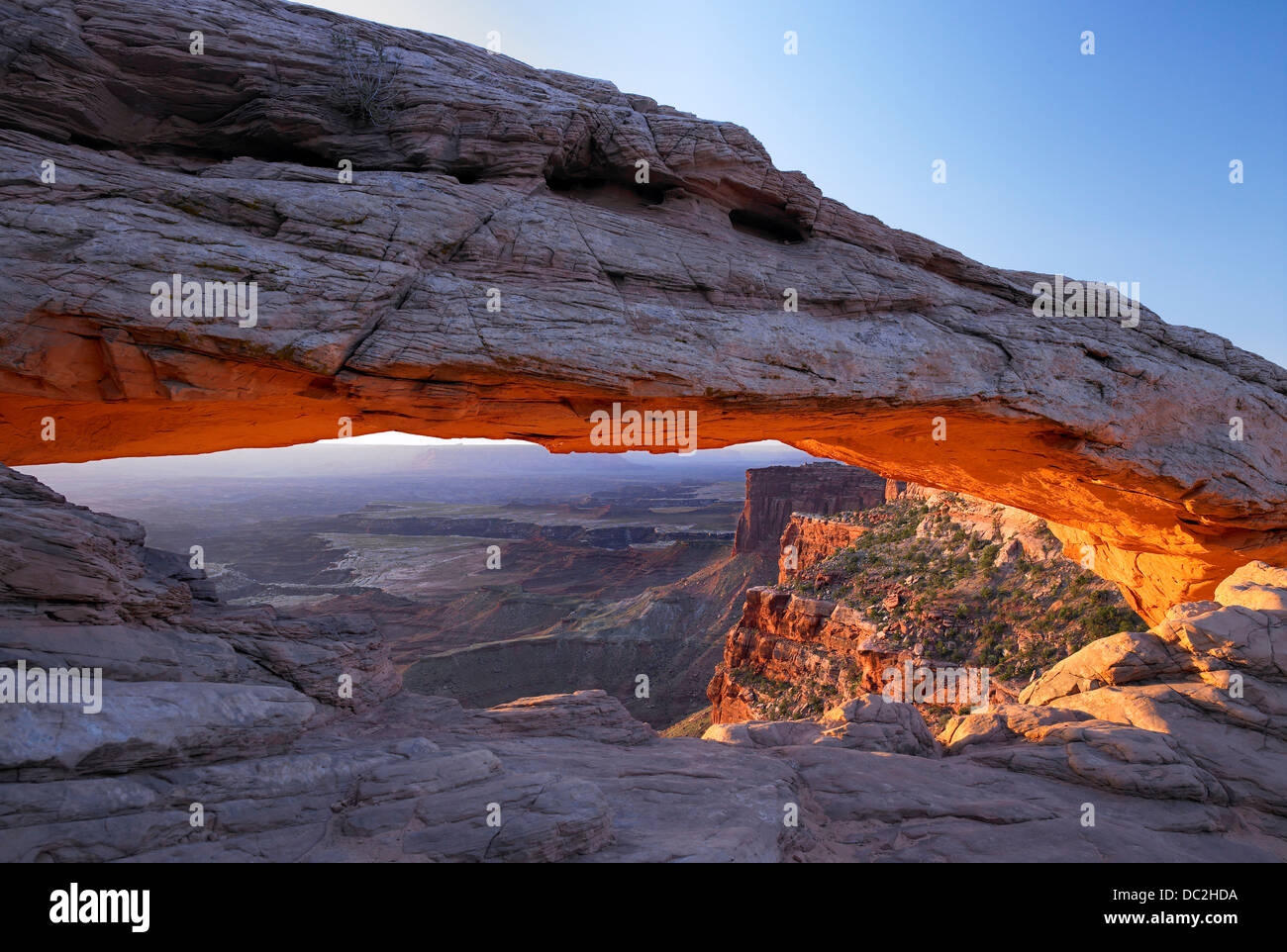 Bagliore del sole nascente sotto Mesa Arch, Canyonlands. Foto Stock