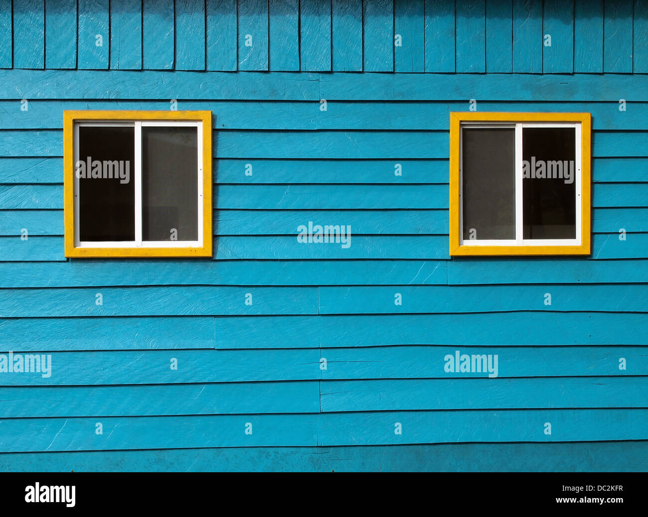 Rustico in legno blu parete con due finestre Foto Stock