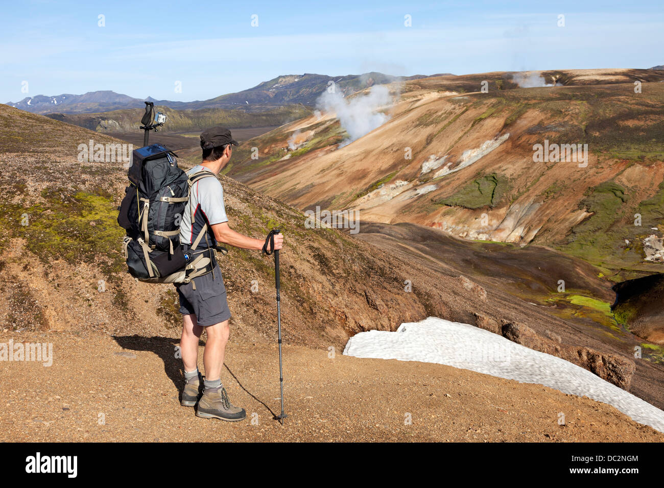 Escursionista guardando verso il vapore vulcanico aeratori del Laugavegur Hiking Trail Fjallabak Islanda Foto Stock