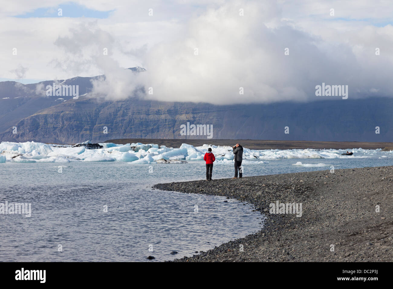 Due persone godendo della vista sulla Jokulsarlon laguna glaciale Vatnajökull Parco Nazionale di Islanda Foto Stock