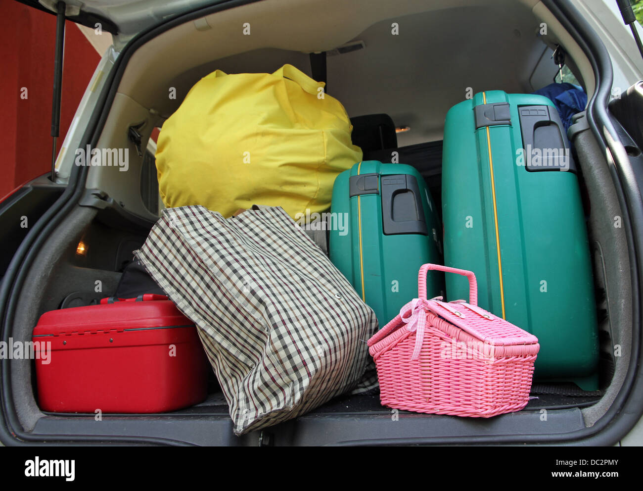 Due valigia verde e un cestino di rosa borsa nel bagagliaio della macchina  di famiglia pronto per le vacanze Foto stock - Alamy