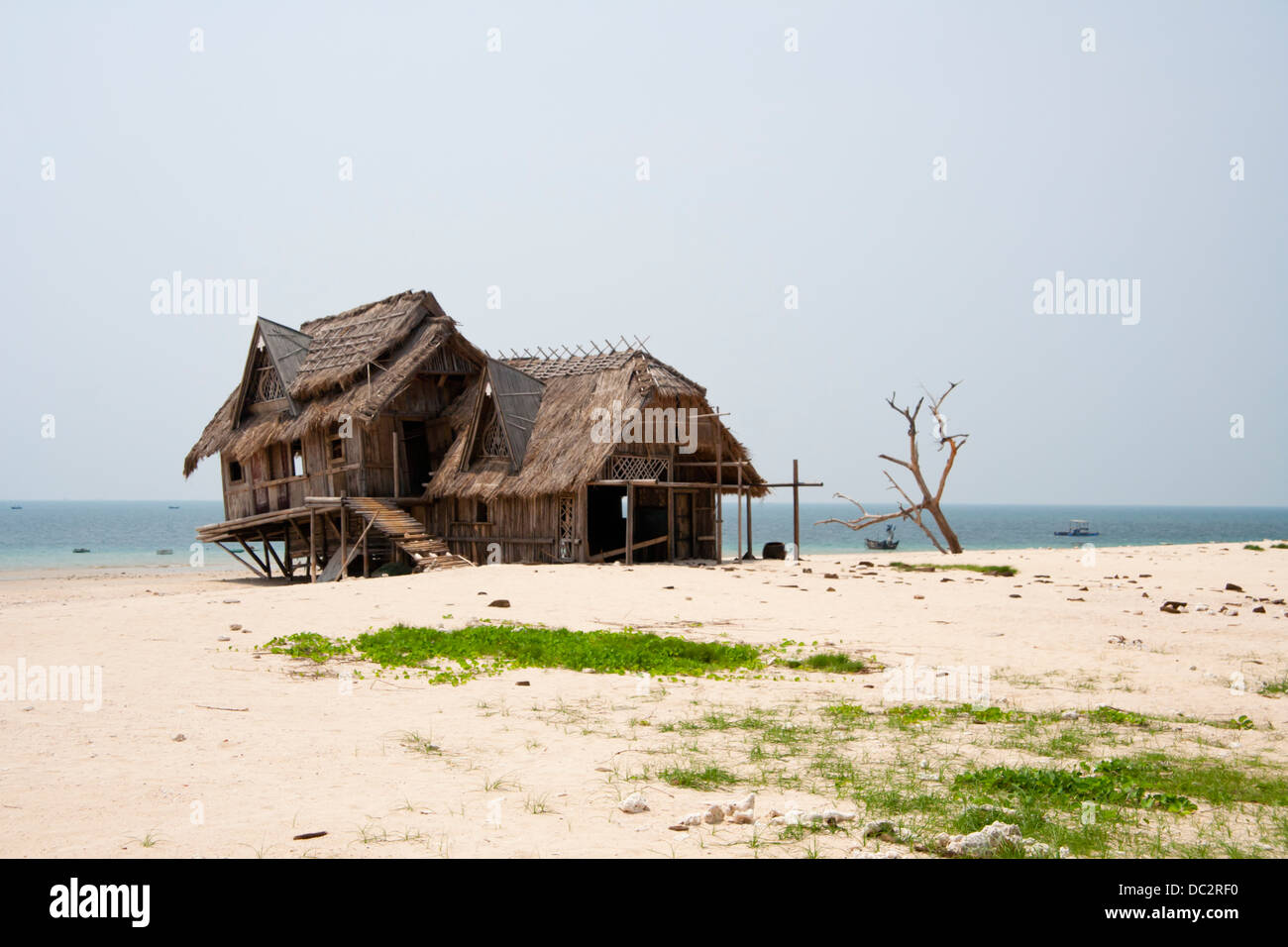 Con il tetto di paglia capanna sulla spiaggia in riva al mare a Foto Stock