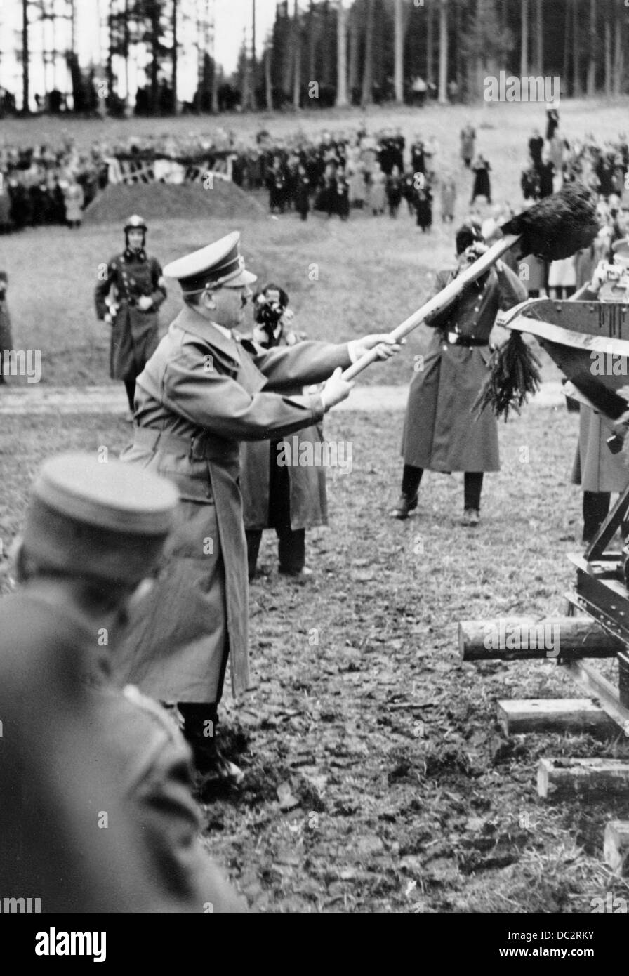 Adolf Hitler viene raffigurato facendo il primo taglio della spade per l'apertura dei lavori di costruzione del Reichsautobahn a Walserberg in Austria, poco dopo l'annessione al Reich tedesco il 7 aprile 1934. La Propaganda nazista! Sul retro dell'immagine è datato 7 aprile 1938: 'Il Führer ha fatto il primo taglio della spade per l'autobahn austriaco. Un momento memorabile: Il Führer fa il primo taglio del vanga per la prima autobahn austriaca." Fotoarchiv für Zeitgeschichte Foto Stock