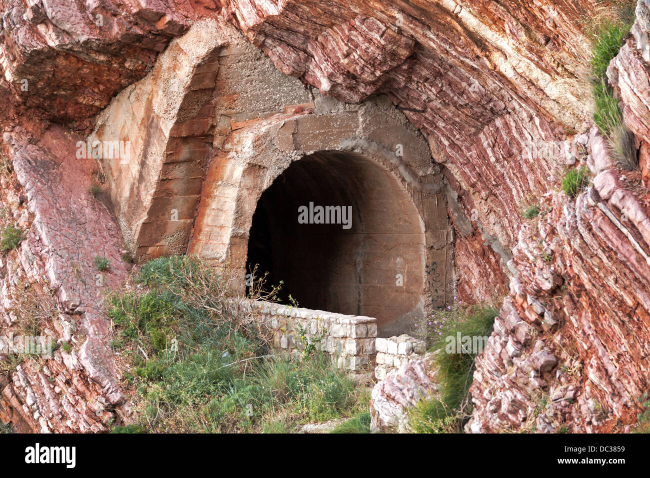 Vecchio portale di tunnel nella roccia rossa Foto Stock