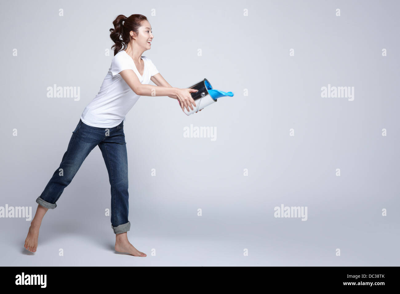 Una signora di gettare una dipinge dal secchio di vernice Foto Stock