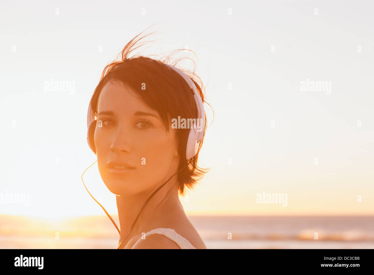 Close up ritratto di fiducioso donna che indossa le cuffie a beach Foto Stock