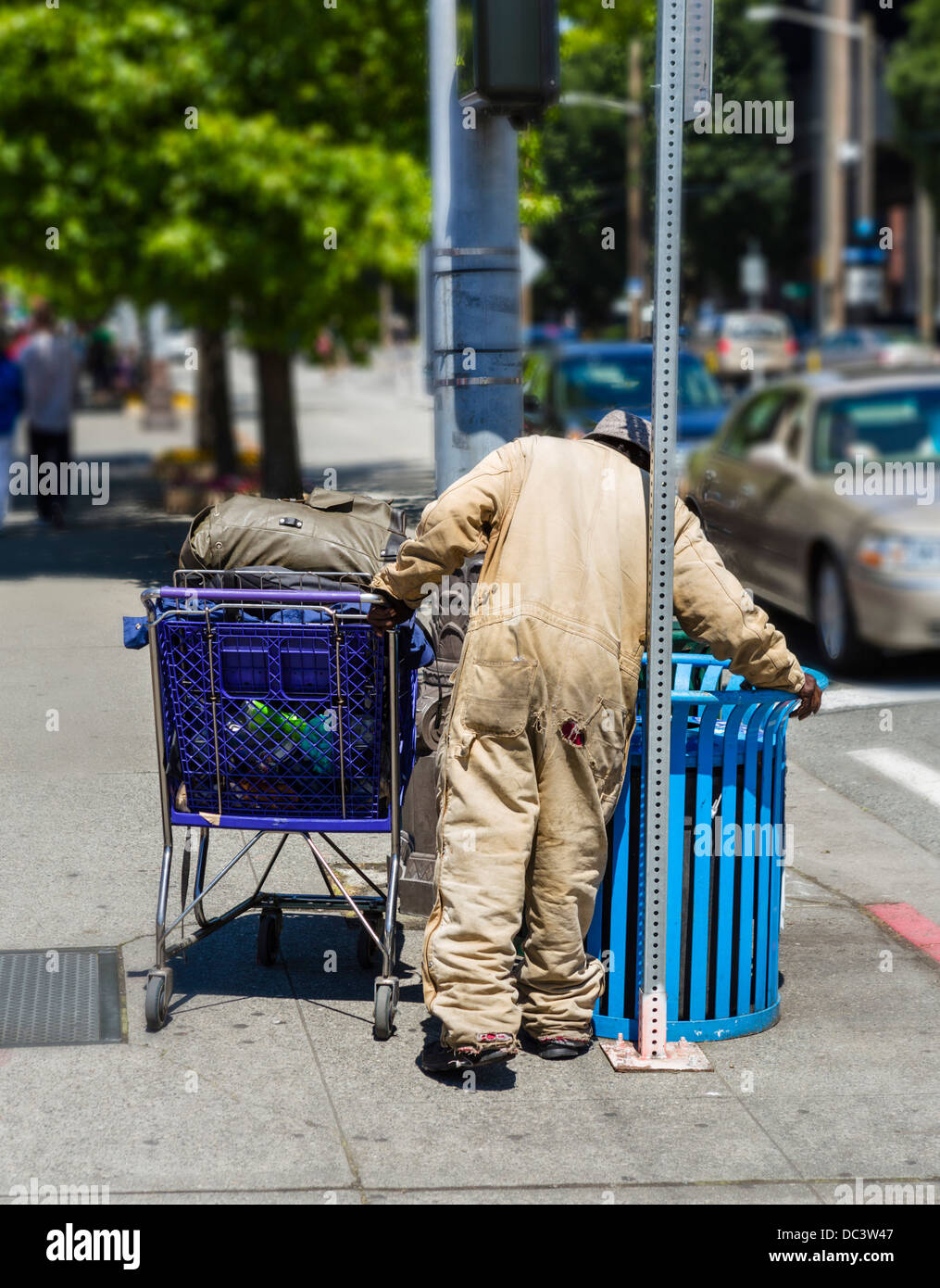 Uomo senza tetto con un carrello lavaggio in un cestino, Seattle, Washington, Stati Uniti d'America Foto Stock