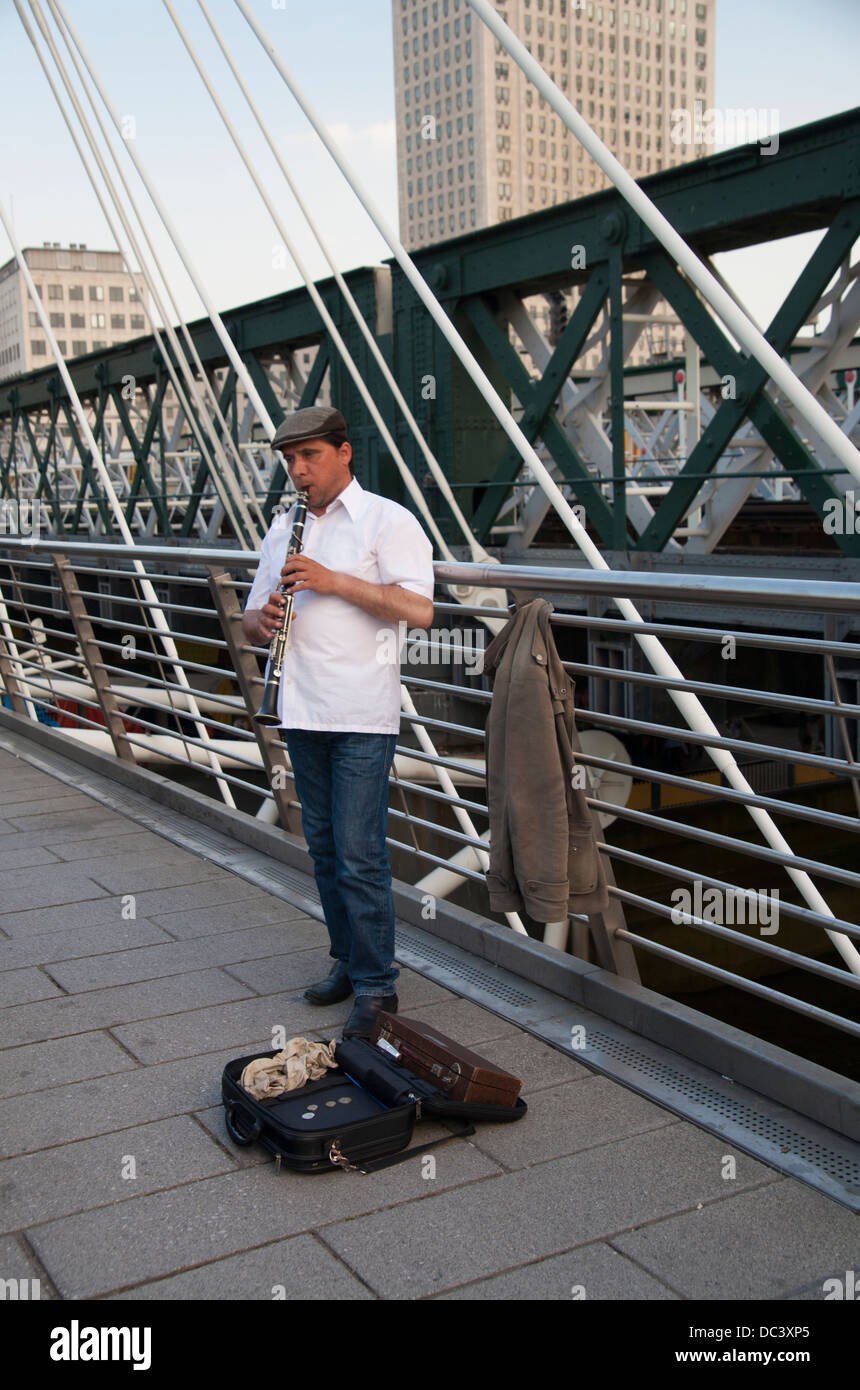 Busker giocando clarinetto su Millennium Bridge, fiume Thames, London, England, Regno Unito, GB. Foto Stock