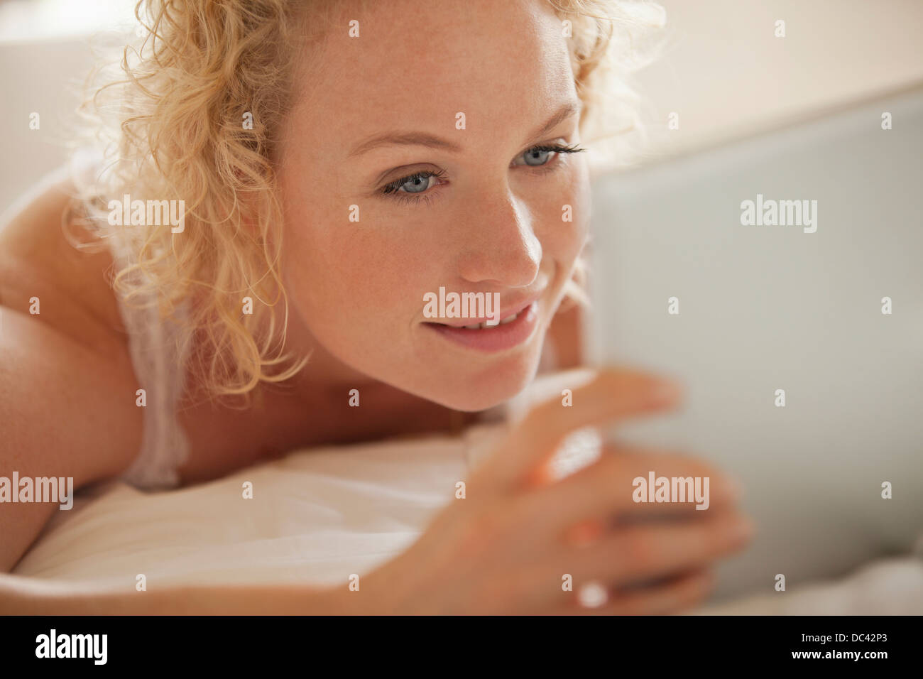 Close up di donna con tavoletta digitale a letto Foto Stock