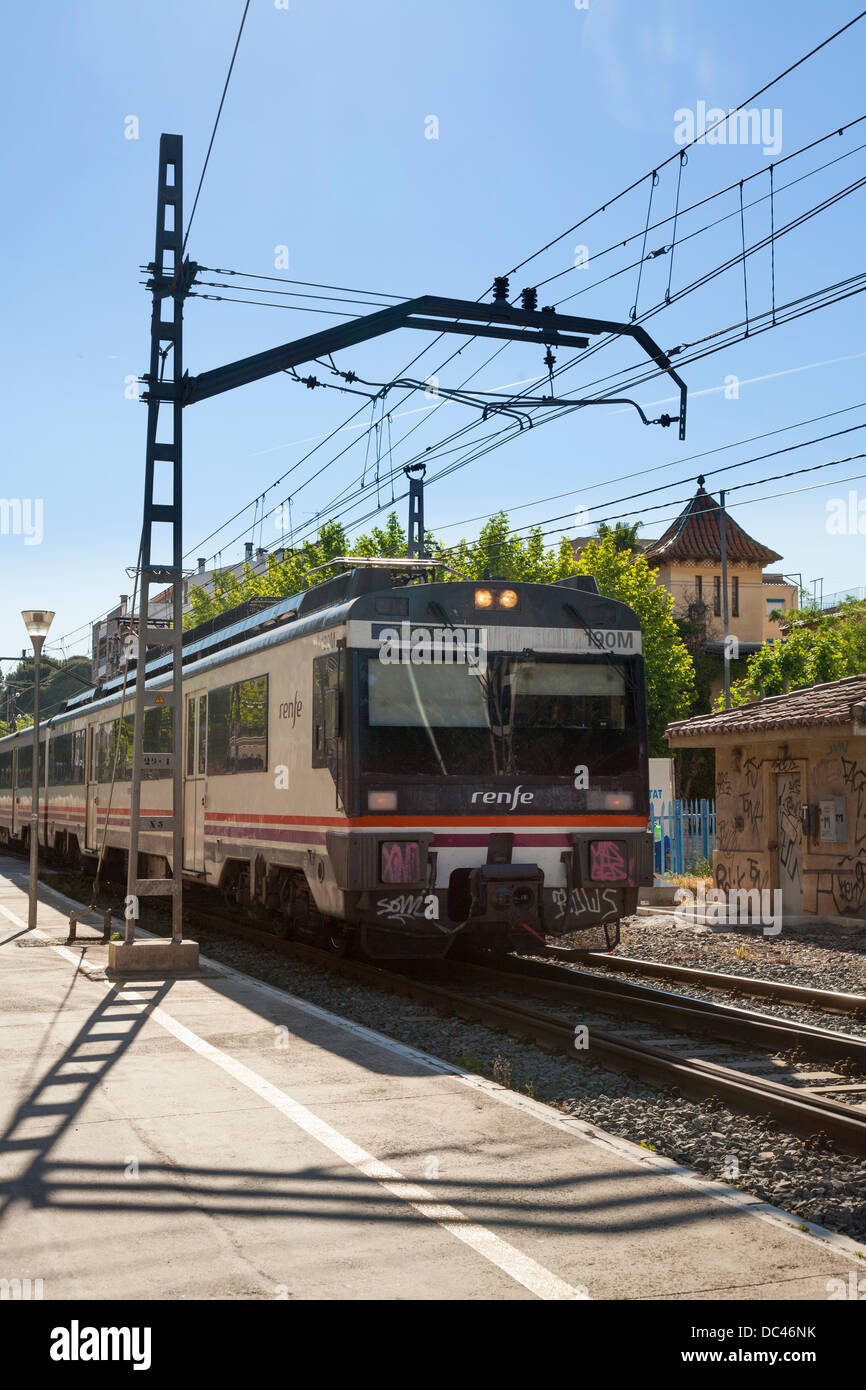 Treno renfe avvicinando piattaforma con linee elettriche aeree Foto Stock