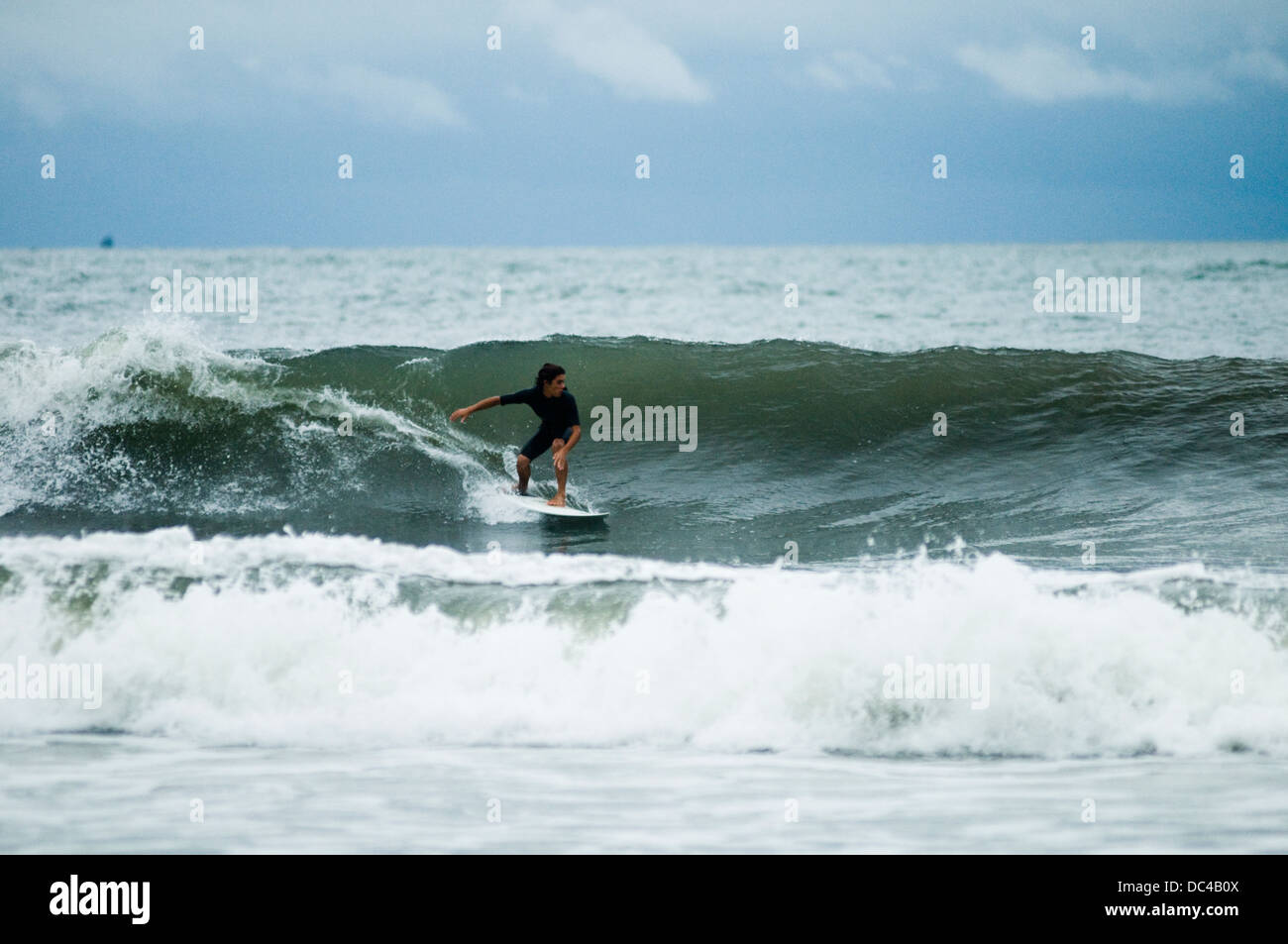 Surfista locale in azione a Caiobá Beach, Matinhos, dello stato del Paraná shore, Brasile del Sud Foto Stock