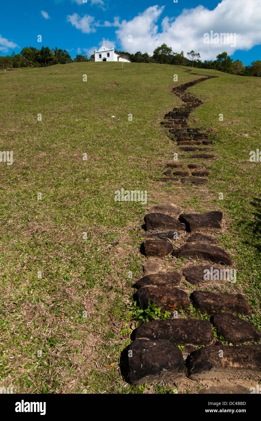 Piccola chiesa cattolica in cima ad una collina con una scala Foto Stock