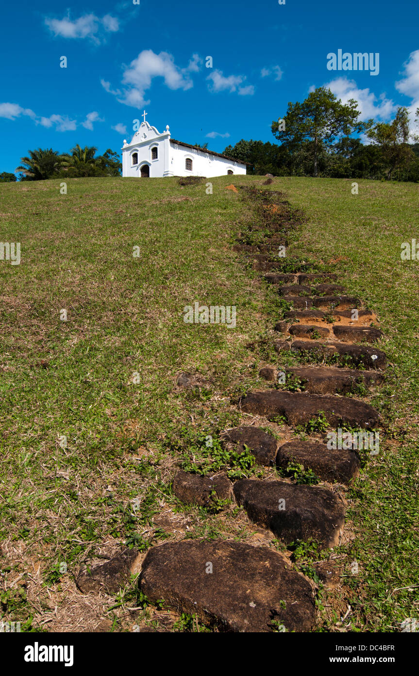 Piccola chiesa cattolica in cima ad una collina con una scala Foto Stock