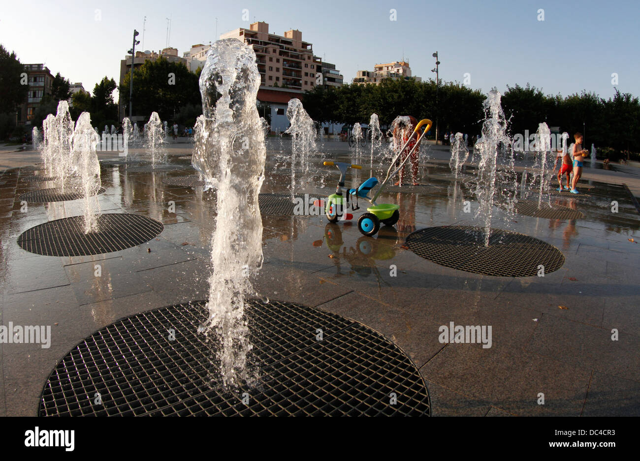 Aggiorna i bambini a giocare sul pavimento fontane durante una ondata di caldo con temperature intorno ai 40 gradi a Maiorca, l'isola spagnola Foto Stock