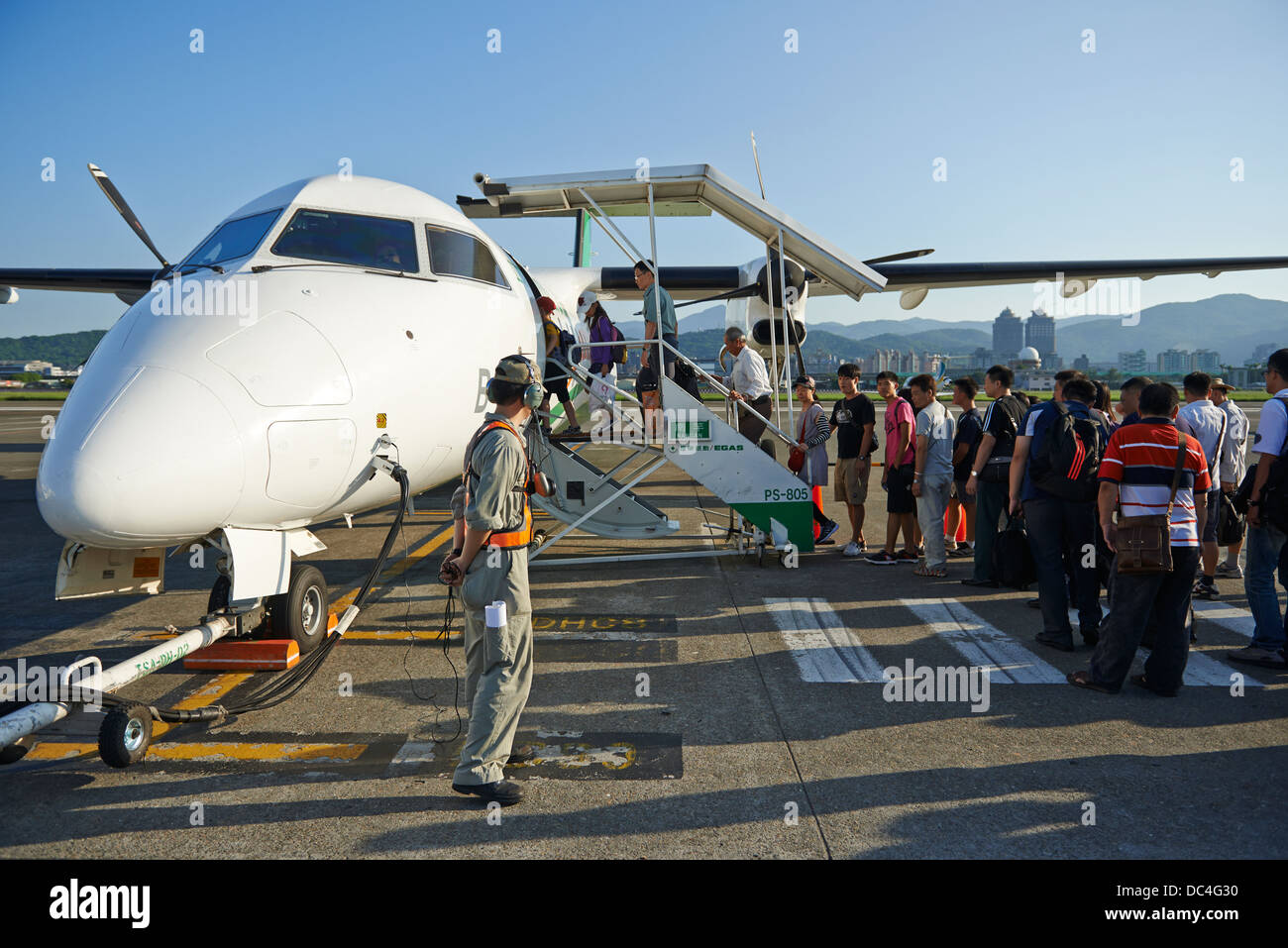 I turisti di salire a bordo di un piccolo aereo ad elica all'Aeroporto Songshan di Taipei, Taiwan. Foto Stock