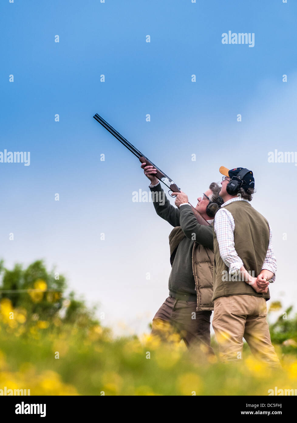 Due uomini di scatto a un gioco di simulazione e di Caccia al gallo cedrone clay shoot Foto Stock