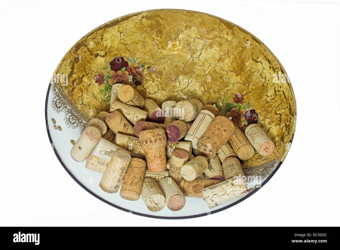 Piatto di vetro decorato con tappi di sughero da vino su sfondo bianco Foto Stock