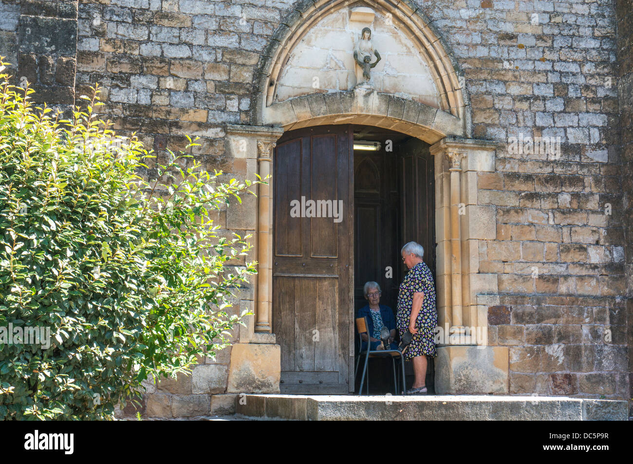 Due vecchi donna all'ingresso della chiesa di Clécy (nel dipartimento di Calvados di Normandia, a nord ovest della Francia). Foto Stock