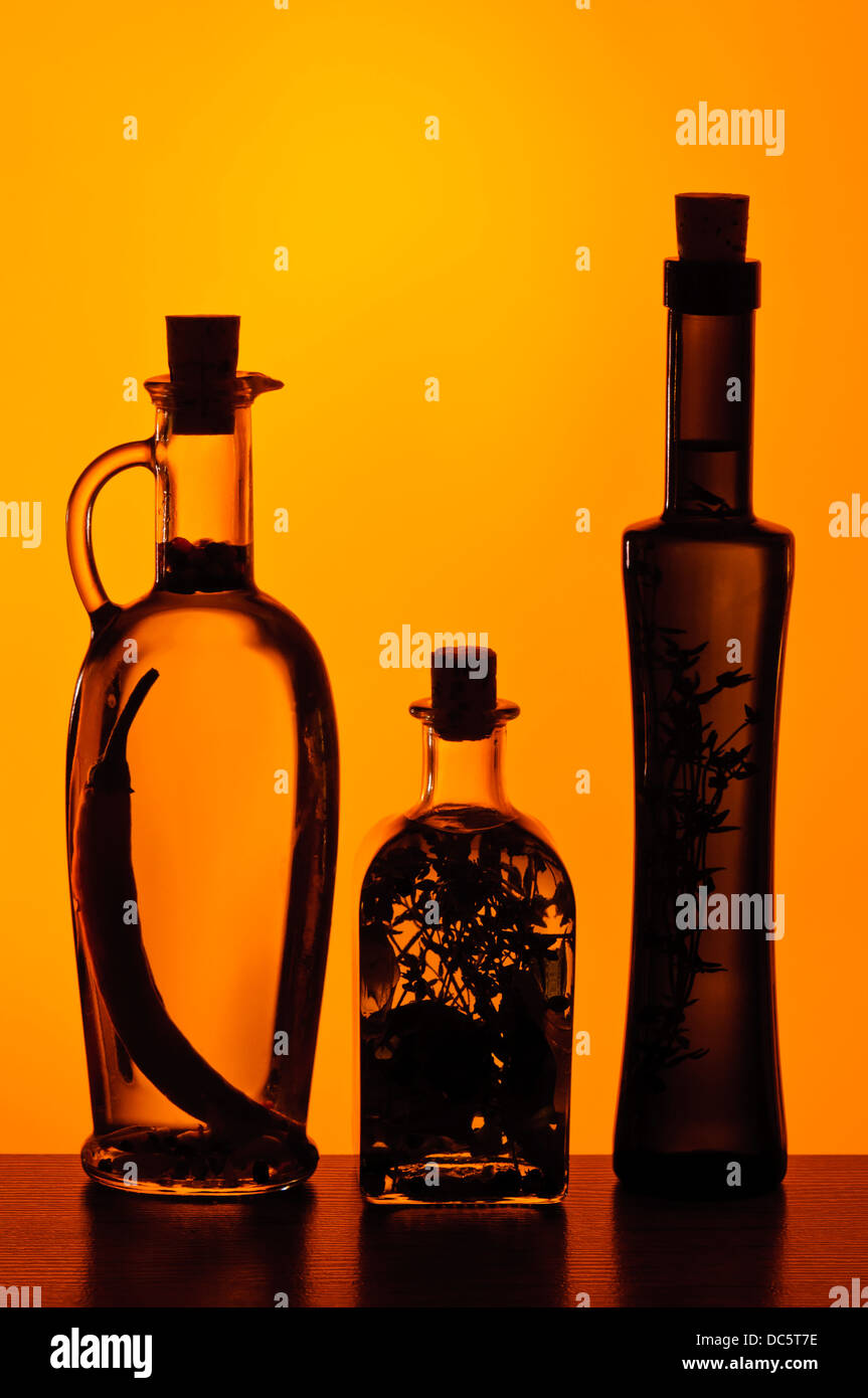 Diverse bottiglie con infusi alle erbe o olio di oliva Foto Stock