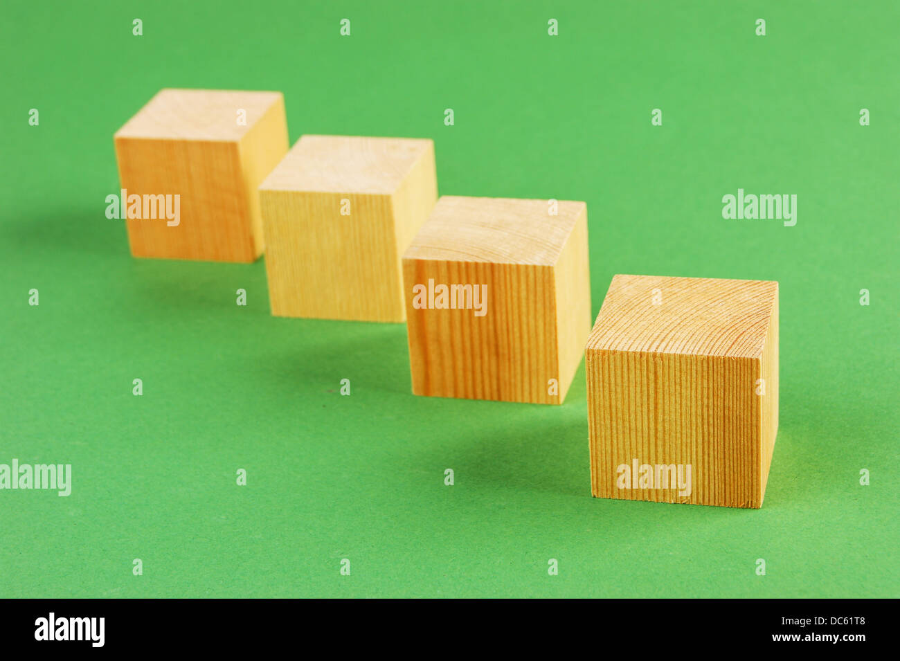 In legno cubo geometrico su uno sfondo verde Foto Stock