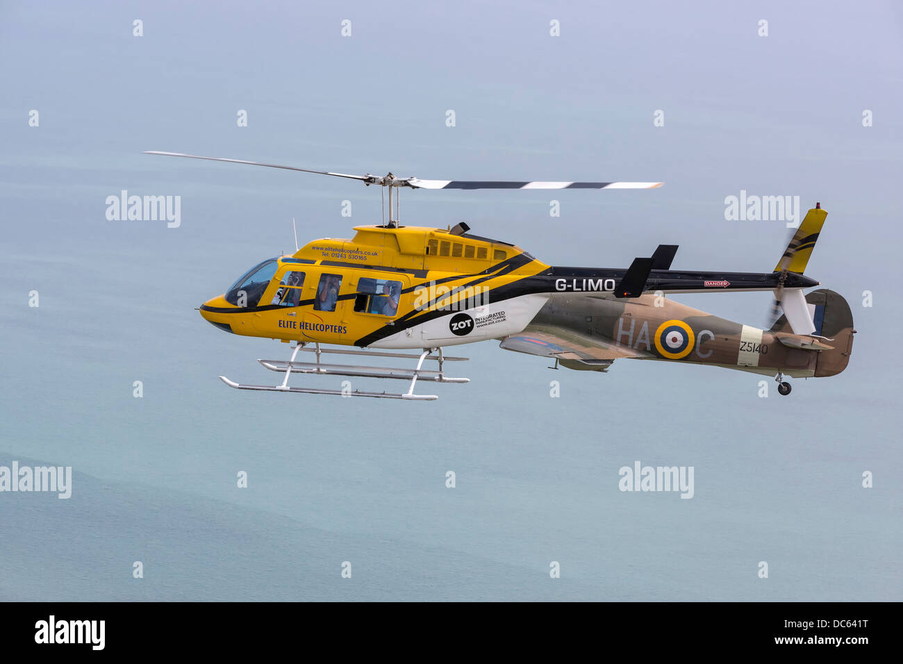 Aria ad aria con una classica guerra mondiale due fighter - un Hawker Hurricane X11a in formazione con un elicottero Longranger Foto Stock