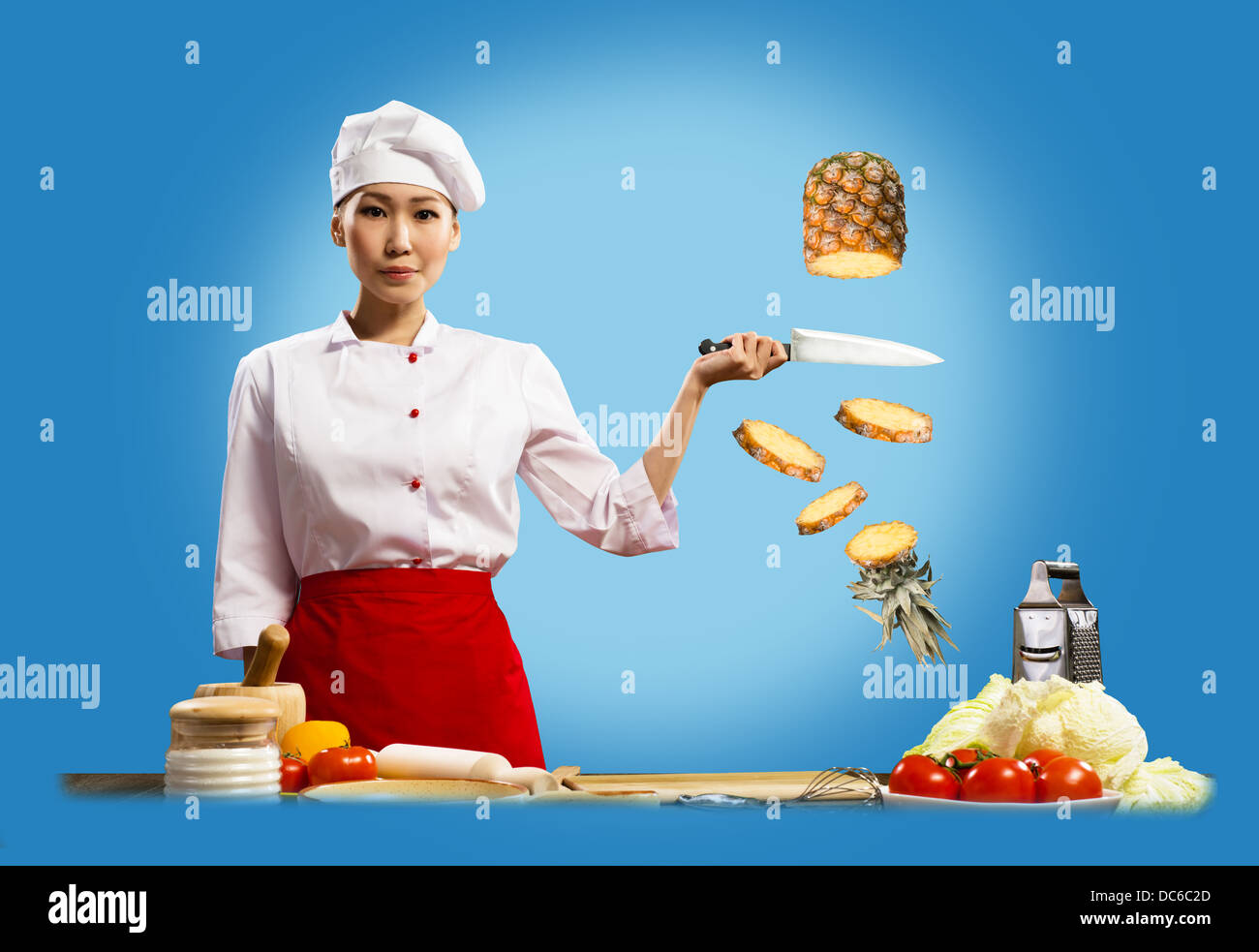 Asian chef femmina taglia ananas Foto Stock