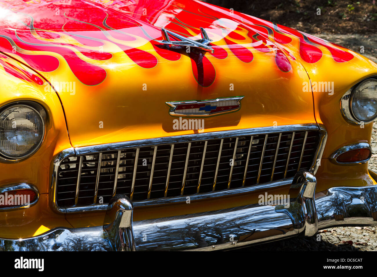 Primo piano frontale schematica di un meravigliosamente restaurato custom 1955 Chevrolet con vernice gialla e fiamme rosse. Foto Stock