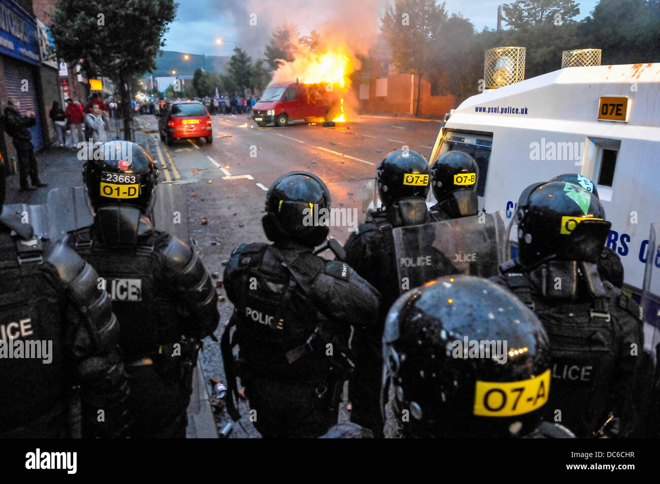 Belfast, Irlanda del Nord. 9 agosto 2013 - PSNI ufficiali in tenuta da sommossa guardare come una folla di i manifestanti avevano appiccato il fuoco ad un furgone sulla Shankill Road, Belfast Credit: stephen Barnes/Alamy Live News Foto Stock