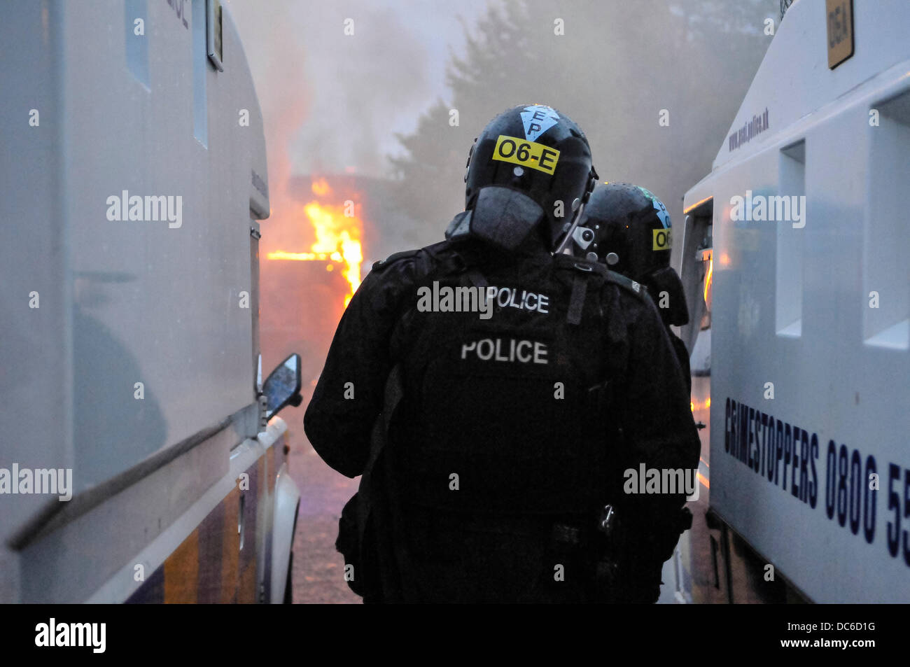 Belfast, Irlanda del Nord. 9 agosto 2013 - PSNI ufficiali guardare dopo una folla di protestare lealisti avviare una sommossa contro la polizia e impostare un furgone sul fuoco a Belfast Credit: stephen Barnes/Alamy Live News Foto Stock