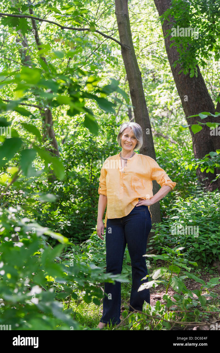 Stati Uniti d'America, dallo Stato di New York New York City Central Park, Senior woman hiking in foresta Foto Stock