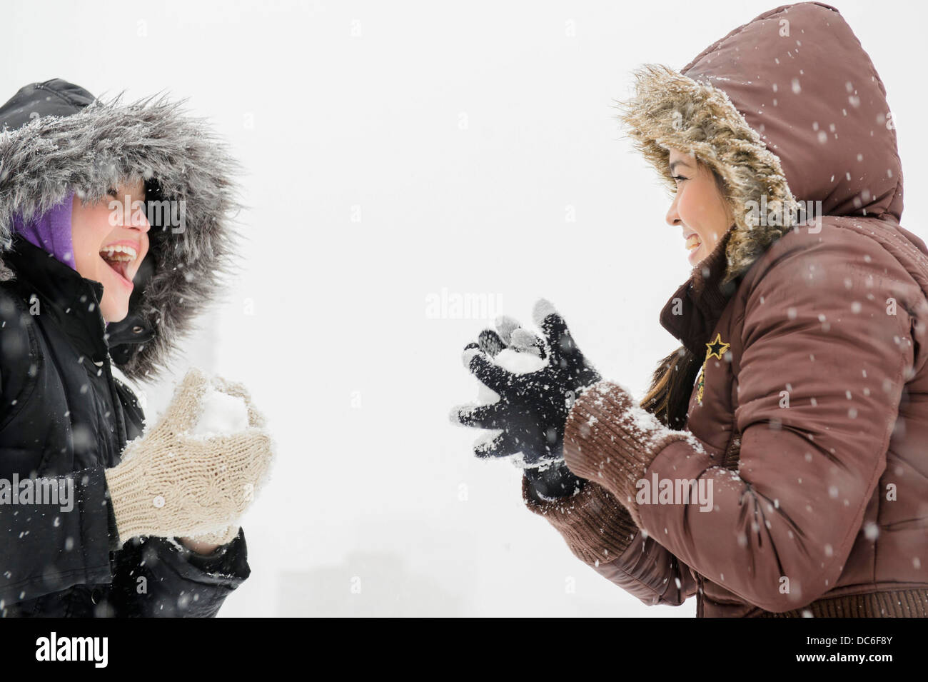 Due giovani donne aventi snowball volo Foto Stock