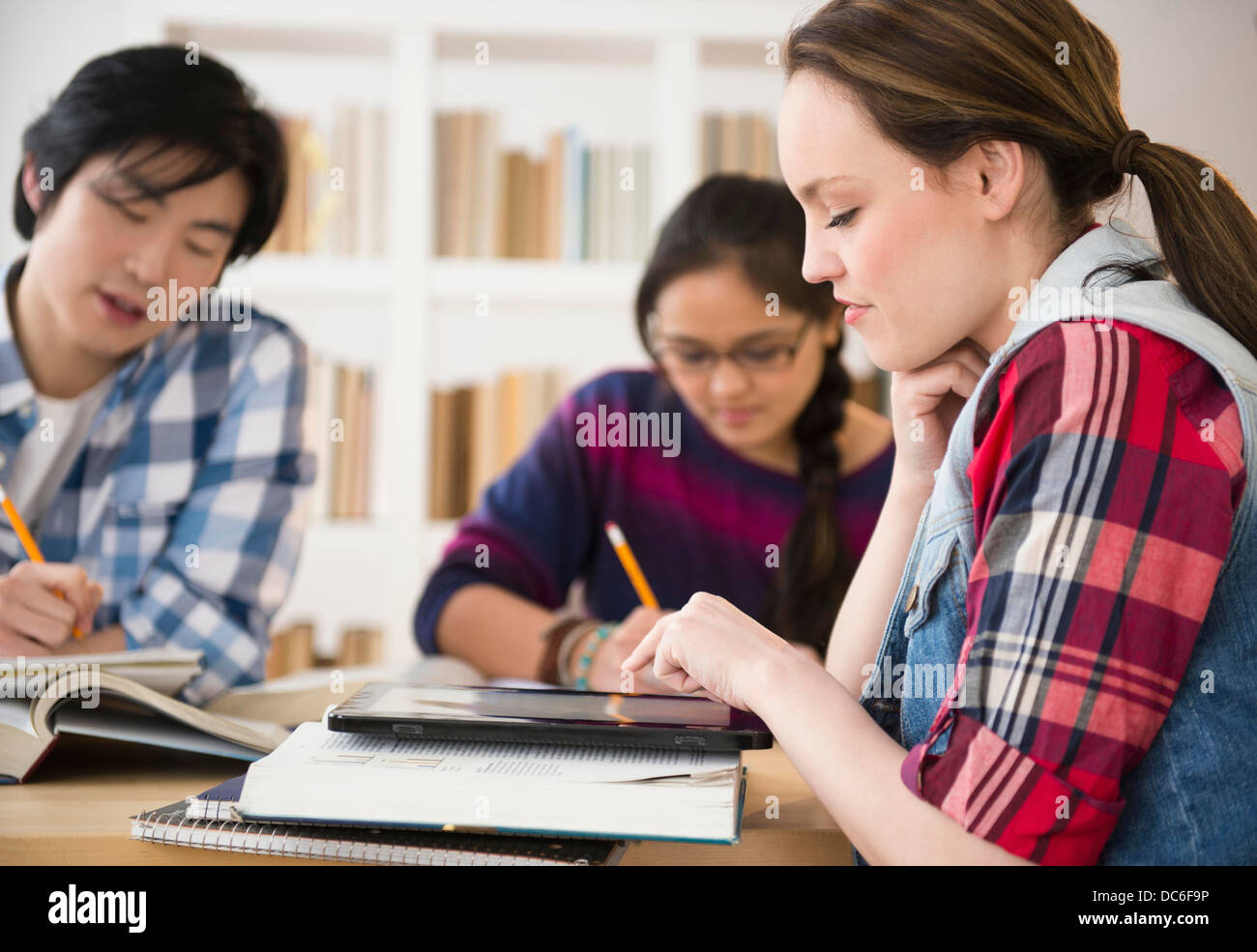 Giovani donne e uomini prigionieri nella libreria Foto Stock